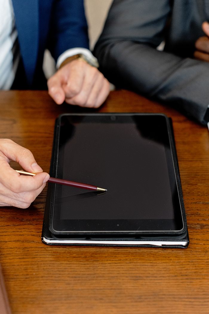 services-09 Business professionals using a digital tablet during a meeting, pointing with a pen on the screen.
